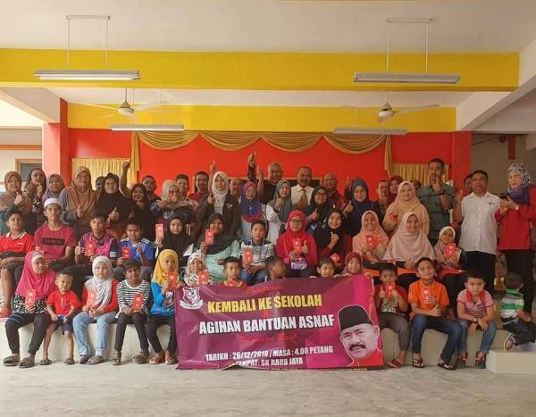 Abu Bakar bergambar bersama para pelajar di kawasan Parlimen Tg Piai, Johor yang menerima bantuan persekolahan, semalam.
