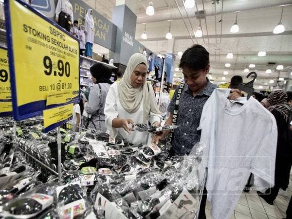 Norlizawati Shahirry, 35, (kiri) membantu anaknya Muhammad Ridzuan Nasrullah Husaini, 16, memilih kelengkapan sekolah. - Foto Sinar Harian ZAHID IZZANI