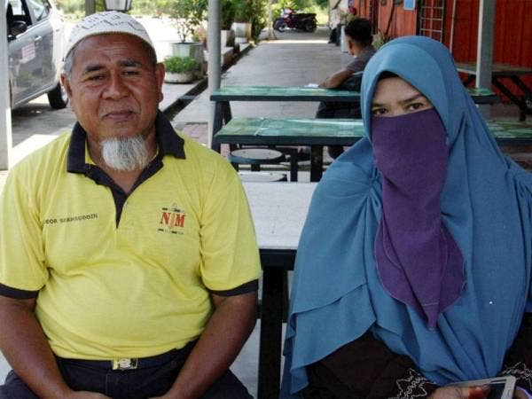 Pasangan pengantin Meor Shamsuddin dan isterinya Che Mah Abdul Rahman yang bersanding di atas rakit di Sungai Perak di Ahad lalu. - Foto Bernama