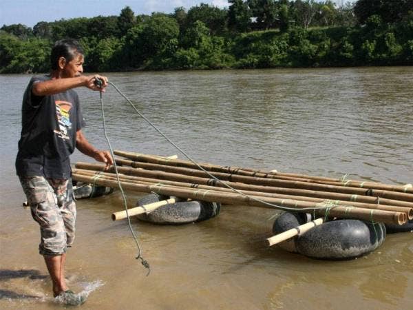 Pembuat rakit Meor Mohamad Mansor Meor Ab Salim, 61, menarik rakit sepanjang 4.57 meter dan lebar 1.22 meter yang digunakan oleh pasangan pengantin warga emas ketika bersanding di atas rakit itu di Sungai Perak pada 22 Disember lepas. - Foto Bernama
