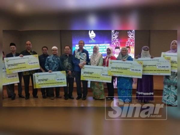 Wan Mohd Zahid (tengah) bersama wakil penerima sumbangan MAIPk ketika program penyampaian yang diadakan di Dewan Al-Ghazali, Kompleks Islam Darul Ridzuan di sini semalam.