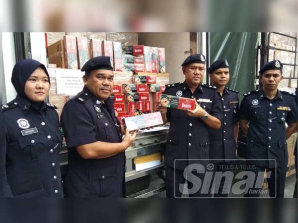 Wan Azharuddin (tengah) menunjukkan rokok seludup yang berjaya dirampas sepasukan polis IPD Tapah ketika sidang media di IPD Tapah di sini hari ini.