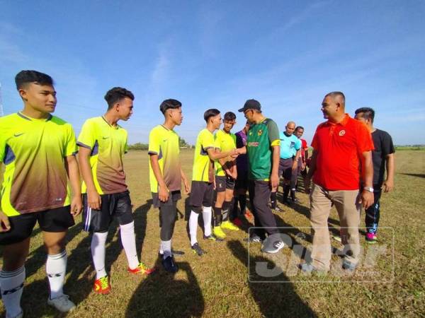 Dr Ismail (dua dari kanan) beramah mesra dengan pasukan yang mengambil bahagian dalam Kejohanan Bola Sepak 9 Sebelah Piala Dr Ismail Salleh di Sekolah Menengah Kebangsaan Muadzam Shah, Kota Sarang Semut hari ini.