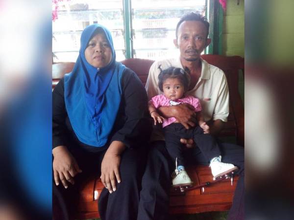 Mohd Salleh dan Roziana memangku Alesha Iezarah yang menghidap penyakit jantung berlubang serta tiga lagi penyakit lain di rumah mereka di Kampung Nelayan Benut.