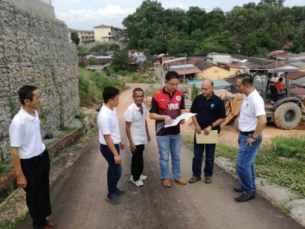 Kok Seong (tiga dari kanan) bersama Raja Norazli (dua dari kanan) ketika melawat lokasi penstabilan cerun di Bahau.