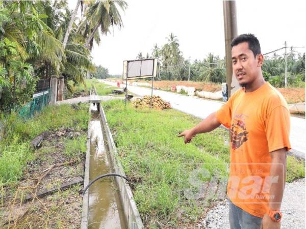 Muhamad Solehan menunjukkan keadaan longkang konkrit yang terlalu tinggi di Kampung Sungai Apong di sini.