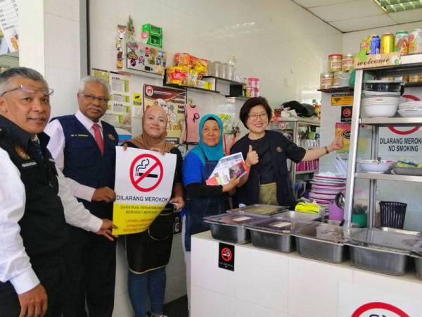 Sivanesan (dua dari kiri) mengedarkan tanda larangan merokok ketika tinjauan ke Medan Selera Dato' Sagor hari ini.