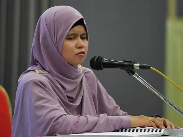 Afzam memperdengarkan bacaan ayat suci al-Quran selepas dinobatkan sebagai johan pada Majlis Tilawah AL-Quran Braille Peringkat Negeri Terengganu di Menara Yayasan Terengganu hari ini. - Foto Bernama