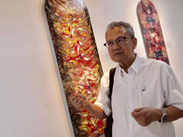 Anwar menerangkan karya Tempo-Alam Menyukat Waktu pada pameran lukisan di Aswara, di sini hari ini. - FOTO ZAHID IZZANI