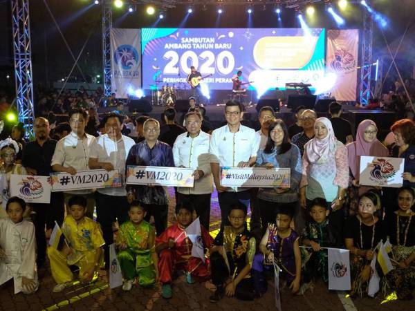 Kar Hing (belakang, tengah) bergambar bersama pengunjung yang hadir meraikan sambutan Tahun Baharu 2020 di Dataran Maritim malam tadi. - Foto Bernama