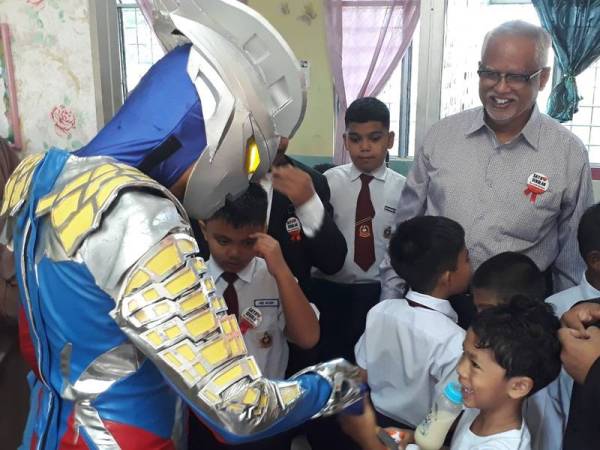 Mahfuz (tiga dari kanan) melihat maskot ultraman yang dibawanya menceriakan murid-murid pendidikan khas Sekolah Kebangsaan Taman Awana hari ini.