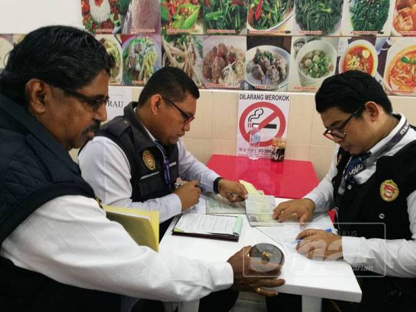 Salah seorang pegawai penguatkuasa Jabatan Kesihatan Negeri menunjukkan bekas abu rokok yang ditemui dalam sebuah kedai makan di Seremban.
