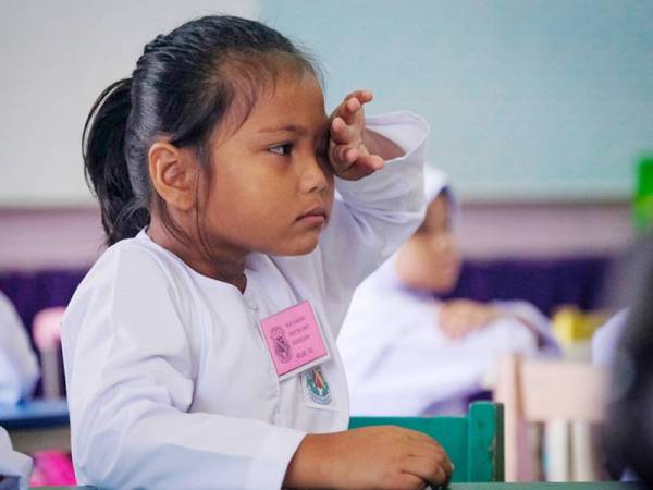 Seorang murid tahun satu Nur Syakira Airiessa Nazarudin mengesat air mata sewaktu sesi pembelajaran berlangsung pada hari pertama sesi persekolahan 2020 yang bermula hari ini di Sekolah Kebangsaan Convent Infant Jesus dekat Bandar Hilir. - Foto Bernama