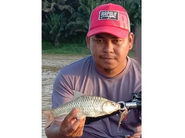 Mangsa merakamkan gambar bersama ikan yang diperoleh sebelum terjatuh.
