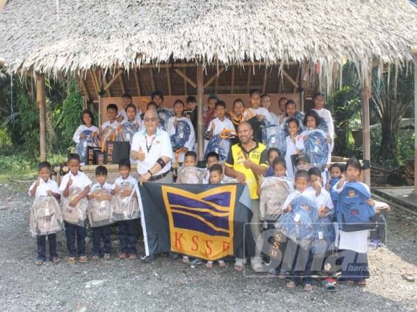 Abd Wahab (lima dari kiri) bersama penerima sumbangan dalam kalangan anak orang asli di Bukit Tadom, Banting baru-baru ini.