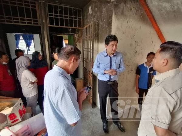 Andrew (tengah) ketika melakukan lawatan di rumah yang terbabit dalam kejadian kebakaran berkenaan.