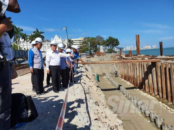 Kon Yeow (tengah) menunjukkan dua laras meriam lama yang ditemui.