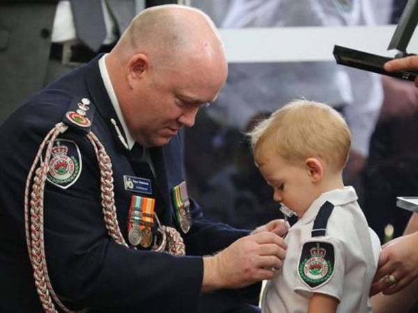 Fitzsimmons memakaikan pingat keberanian bagi perkhidmatan Geoffrey Keaton kepada anaknya, Harvey, kelmarin. - Agensi