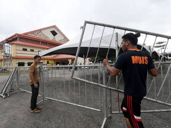 Kerja-kerja memasang pagar keselamatan untuk para penyokong parti yang bertanding pada hari penamaan calon sempena Pilihan Raya Kecil Parlimen Kimanis di Dewan Datuk Seri Panglima Haji Mohd Dun Banir Beaufort dekat sini hari ini. - Foto Bernama