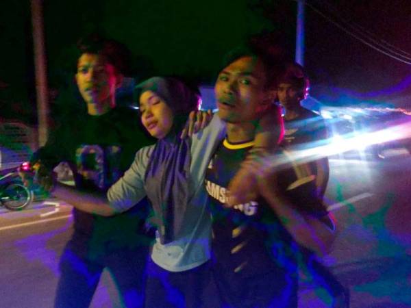 Syairah (tengah) yang longlai sehingga hampir pengsan melihat mayat Mohd Sharifuddin di lokasi kemalangan itu.