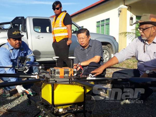 Dari kanan Mahfuz dan Kok Yew melihat dron yang digunakan dalam kerja-kerja meracun di sawah padi.