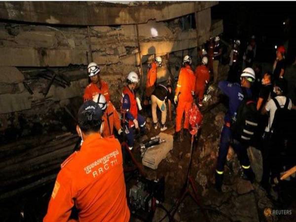 Anggota penyelamat menjalankan usaha mencari mangsa yang terperangkap di bawah runtuhan bangunan di Kemboja. - Foto: Agensi