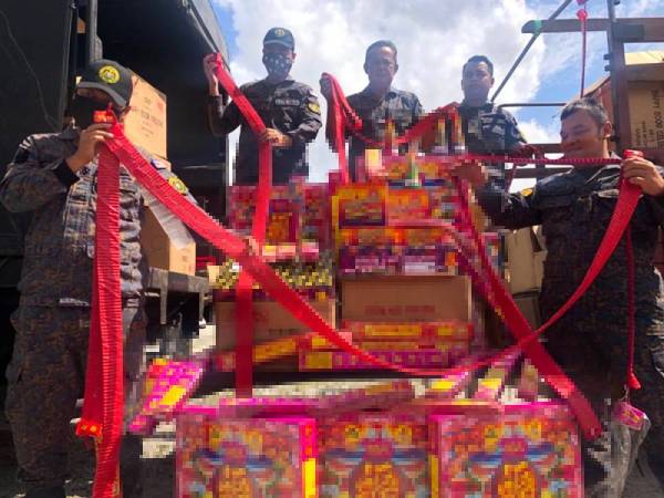 Rusli (tengah) bersama anggota menunjukkan mercun yang dirampas di Pulai Chondong, Machang.