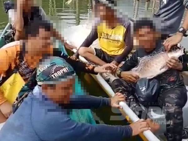 Sekumpulan lelaki bersama ikan kelah yang dimuat naik di media sosial Disember lalu.