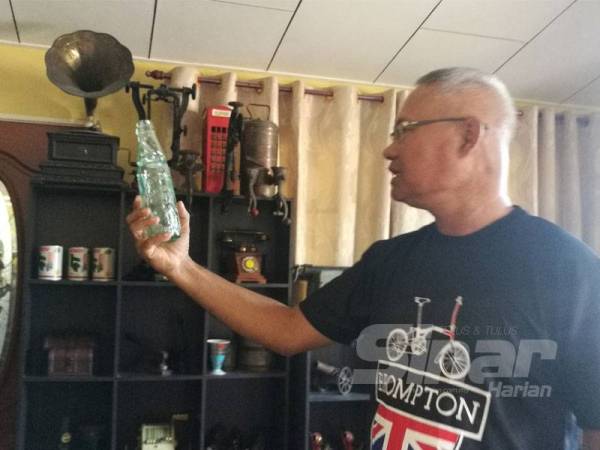 Abdul Aziz memegang botol berusia 130 tahun.