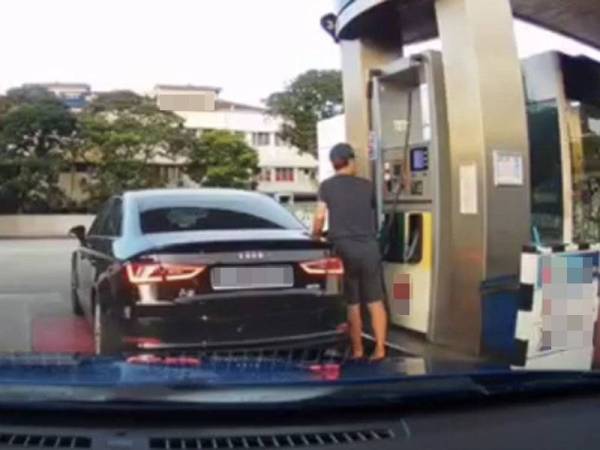 Tangkap layar video menunjukkan seorang warga asing mengisi minyak RON95 pada kenderaannya di sebuah stesen minyak di Johor Bahru.