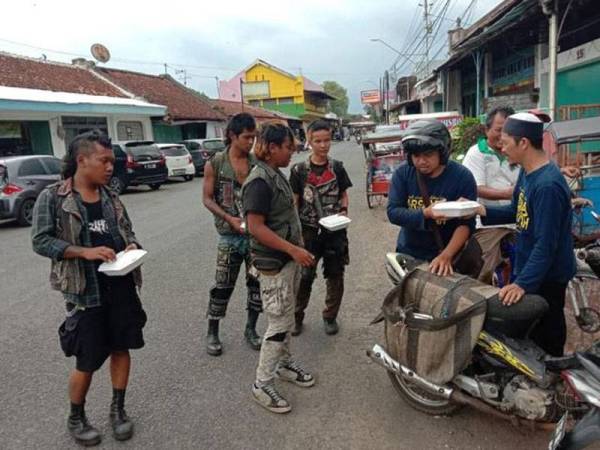 Aktiviti terakhir Allahyarham (kanan) dengan mengagihkan nasi bungkus kepada golongan memerlukan.