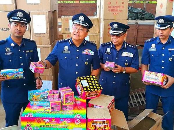 Mohd Rakbi (tiga dari kanan) bersama pegawainya menunjukkan mercun dan bunga api yang dirampas, dipercayai untuk pasaran luar Kelantan.