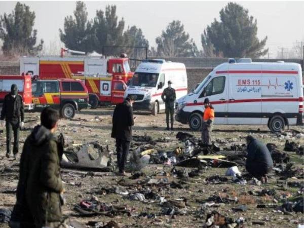 Pasukan penyelamat memeriksa serpihan nahas pesawat yang terhempas berhampiran Tehran. - Foto AFP