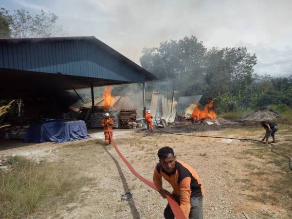 Anggota bomba menjalankan kerja- kerja pemadaman kebakaran stor berkenaan.
