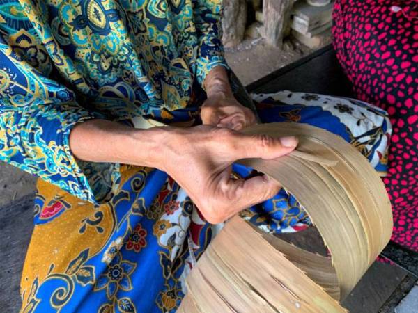 Proses memotong daun mengkuang dilakukan Mok Wan dengan penuh teliti.