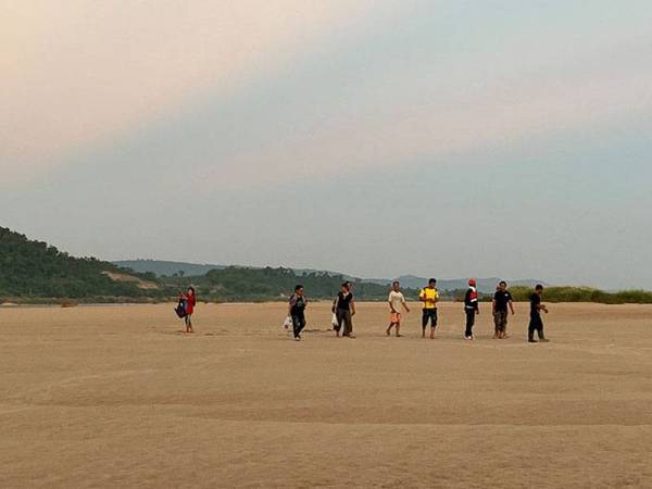 Beberapa penduduk kampung berjalan di atas Sungai Mekong di utara Thailand yang kering Oktober lalu. - Foto Agensi