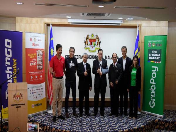 Lim Guan Eng (tengah) bergambar bersama tiga pengendali e-Dompet yang terpilih selepas sidang media mengenai Pengumuman Pelancaran Inisiatif e-Tunai Rakyat di Kementerian Kewangan hari ini. -Foto Bernama