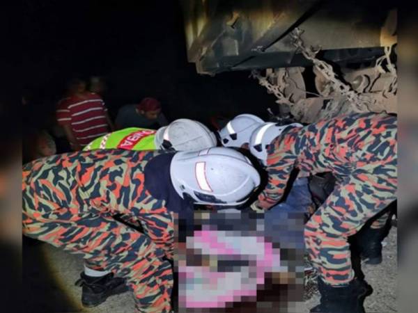 Anggota bomba membantu mengangkat mayat mangsa yang maut dalam kemalangan di KM3 Jalan Salong-Pekan kelmarin. GAMBAR IHSAN BOMBA