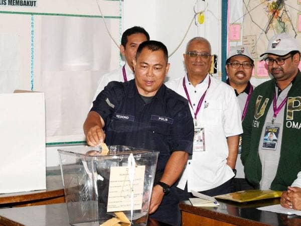Koperal Redond Sadong memasukkan kertas undi sewaktu mengundi awal di Pusat Pengundian Awal di Bilik Gerakan Balai Polis Membakut pada Pilihan Raya Kecil (PRK) Parlimen Kimanis hari ini. Foto: Bernama