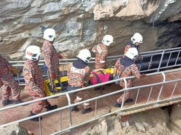 Mangsa diusung oleh anggota bomba keluar dari Gua Kelam.