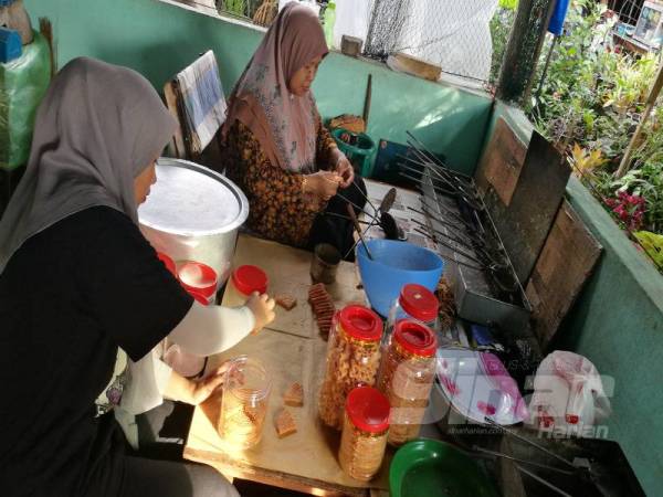 Kamsiah dibantu anak bongsunya.