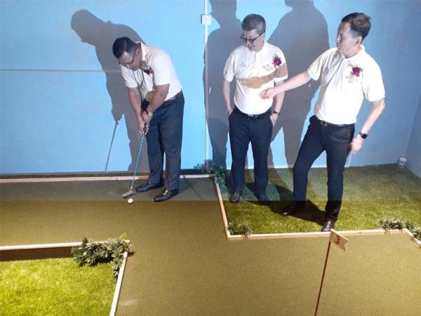 Amirudin (kiri) mencuba permainan golf di fasiliti yang disediakan di kediaman pangsapuri di BSP21.