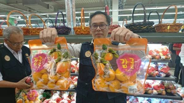 Chee Leong menunjukkan buah oren yang tidak mempunyai label pengimport ketika operasi itu.