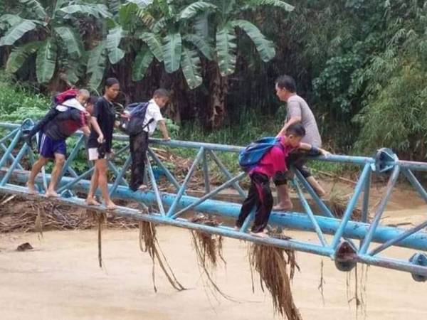 Kanak-kanak terpaksa melalui saluran paip menyeberangi sungai kerana jambatan ditenggelami air.