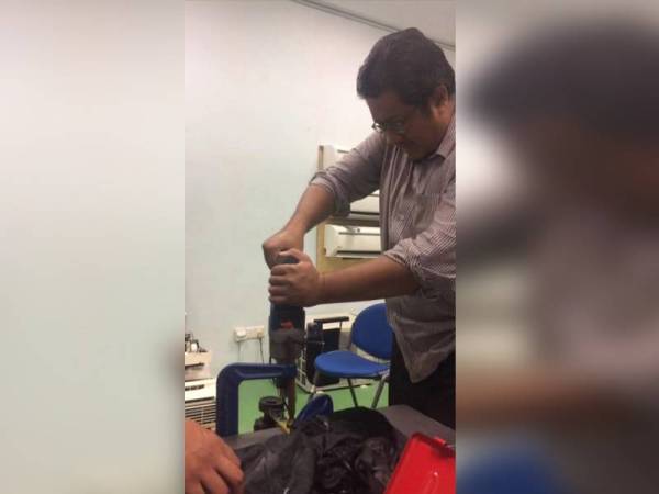 Mohd Firdaus ketika kerja-kerja menyiapkan mesin pengupas kulit dan pelerai biji jagung yang dihasilkannya bersama kumpulan penyelidik Kolej Komuniti Paya Besar.