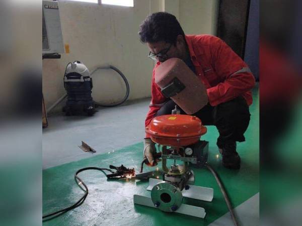 Mohd Hariz ketika kerja-kerja menyiapkan mesin pengupas kulit dan pelerai biji jagung yang dihasilkannya bersama kumpulan penyelidik Kolej Komuniti Paya Besar.