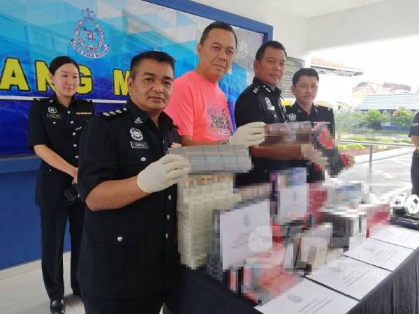 Shamsul Amar (dua dari kanan) menunjukkan antara rokok yang dirampas dalam operasi di premis runcit dan rumah Selasa lalu.