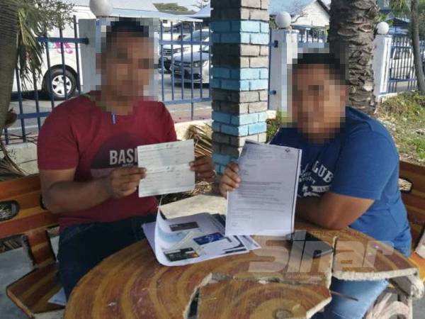 Erie (kanan) bersama salah seorang lagi mangsa yang mahu dikenali Mizi menunjukkan sebahagian dokumen dan cek yang diserahkan suspek kepada mereka sebelum ini.