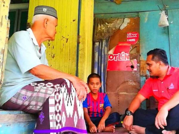 Muhammad Irfan (tengah) bersama datuknya yang dipanggil ayoh menerima kunjungan daripada Presiden Perkam, Mohd Romizu (kanan).