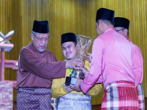 Ahmad (kiri) menyampaikan hadiah johan qari kategori tilawah, Muhammad Qayyim Nizar pada Majlis Pengurniaan Hadiah Tilawah dan Menghafaz Al-Quran Peringkat Negeri Kelantan Tahun 1441H/2020M malam tadi. - Foto Bernama